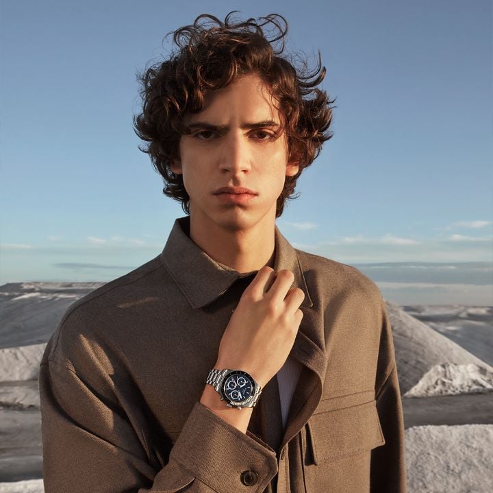 Portrait of a man standing in a white desert, wearing the Tissot PR516 mechanical chronograph on his wrist.