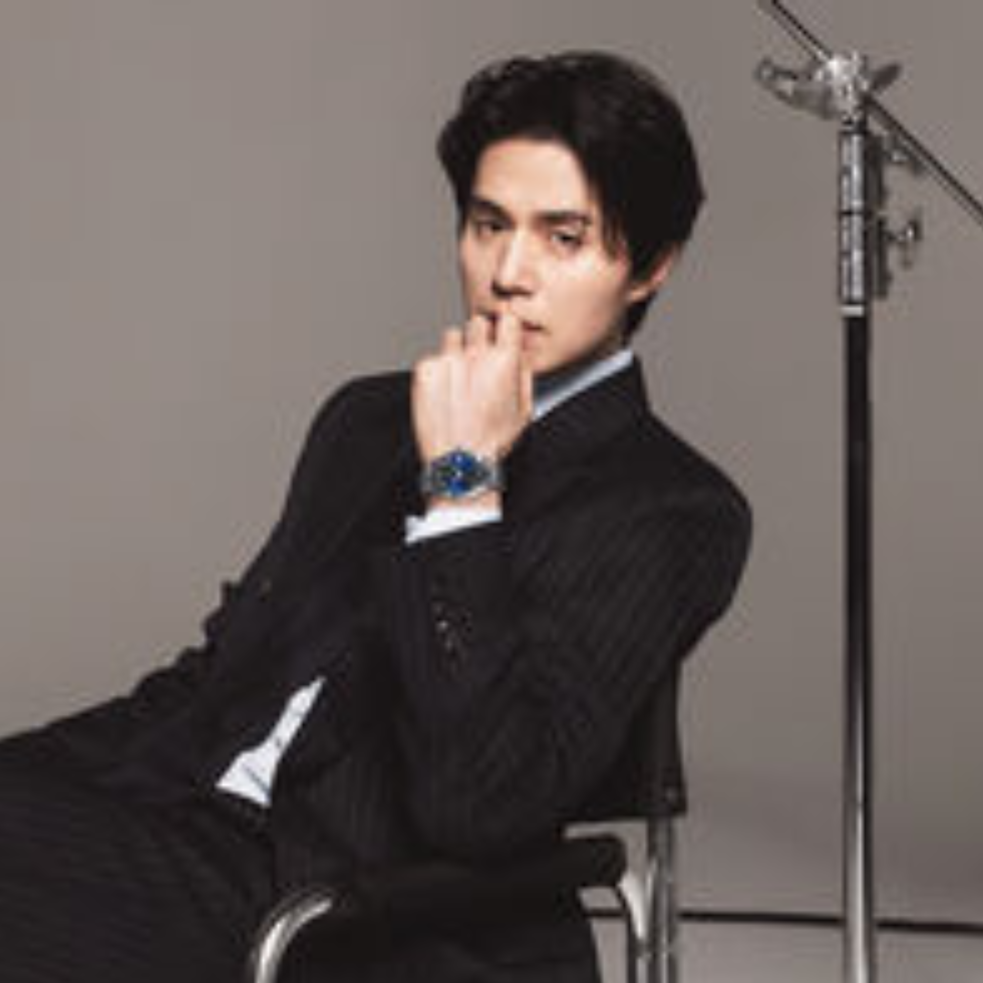 Lee Dong Wook sitting on a studio chair resting his right hand on his chin while wearing the Tissot Gentleman 38mm